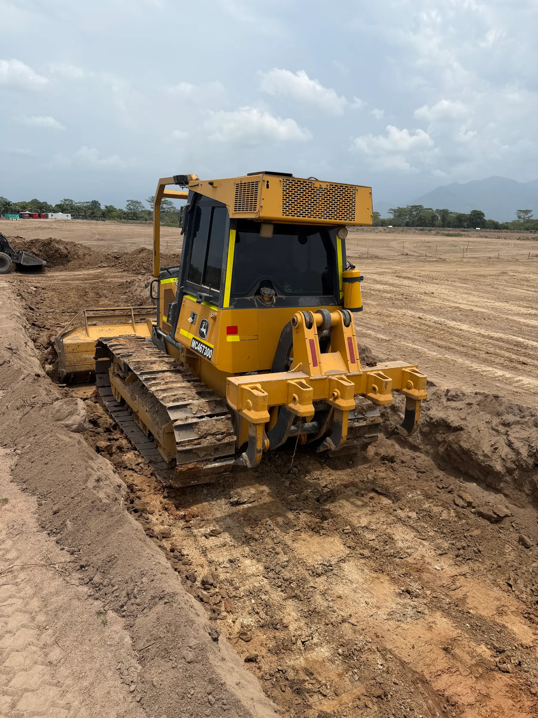 Bulldozer amarillo trabajando en una zanja durante una obra de tierra